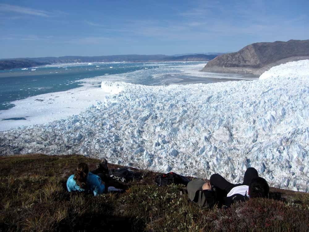 Hikers Enjoying The View Over The Eqi Glacier Front In The Disko Bay In North Greenland