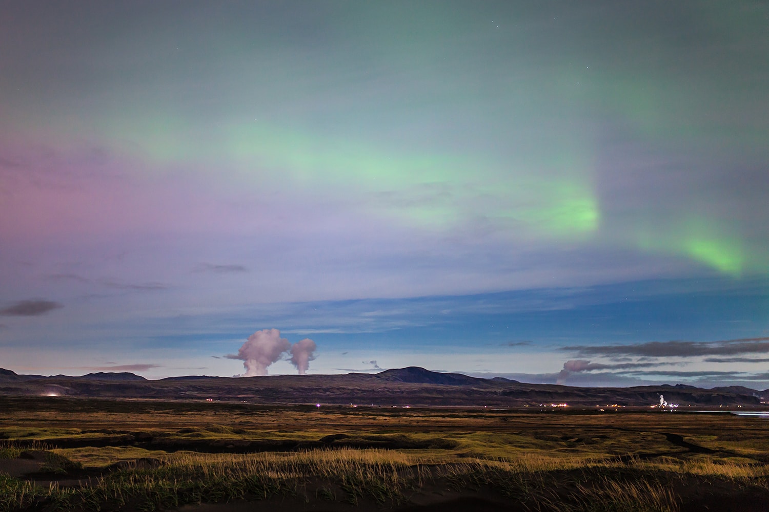 Northern lights and steam from a nearby geothermal area